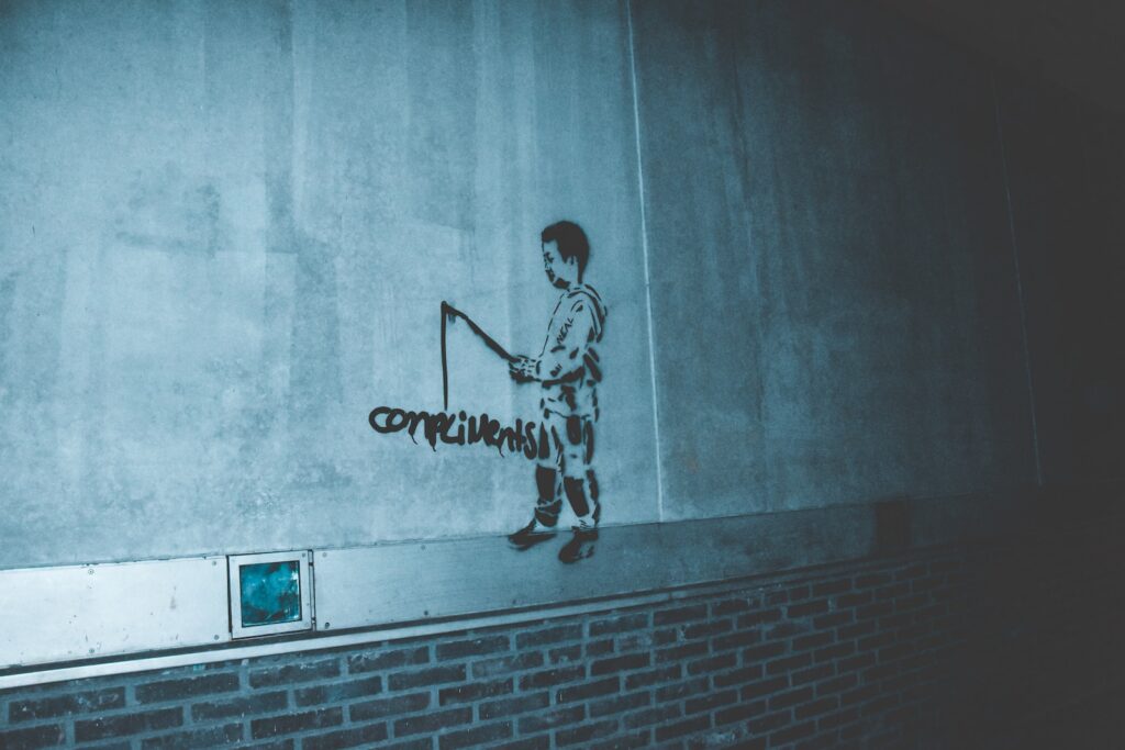 man in black and white shirt and pants standing on gray concrete wall