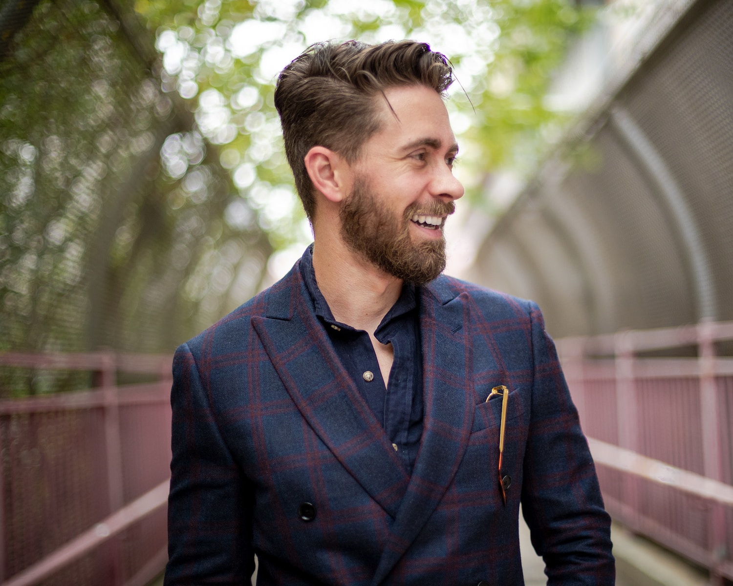 a man with a beard wearing a suit and smiling