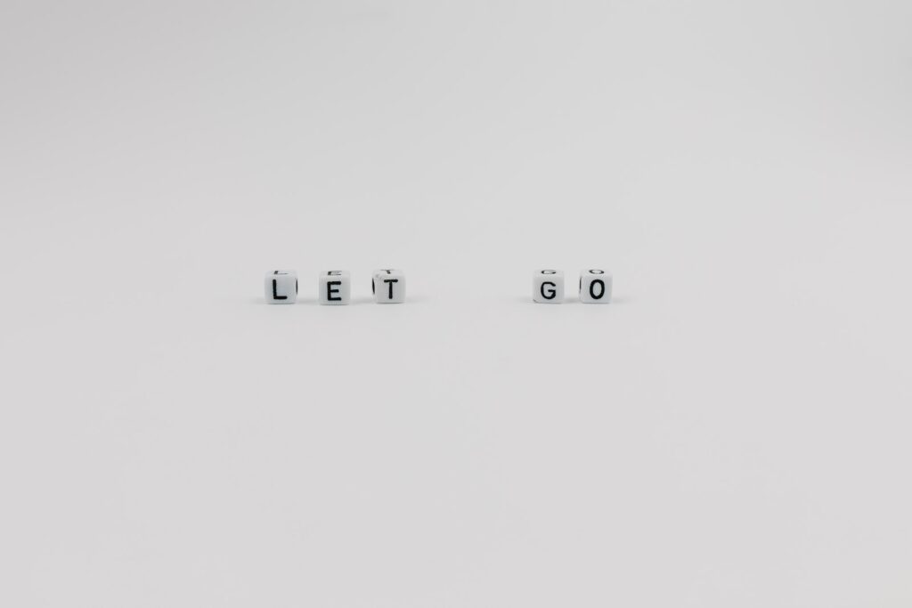 A Let Go Slogan Spelled with Letter Dice on White Background