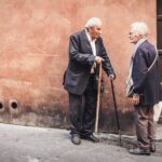 two person talking while standing near wall