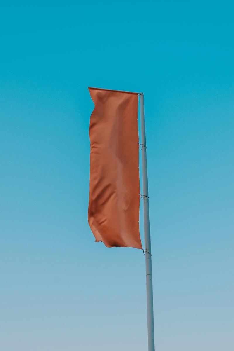 a brown flag is flying in the sky