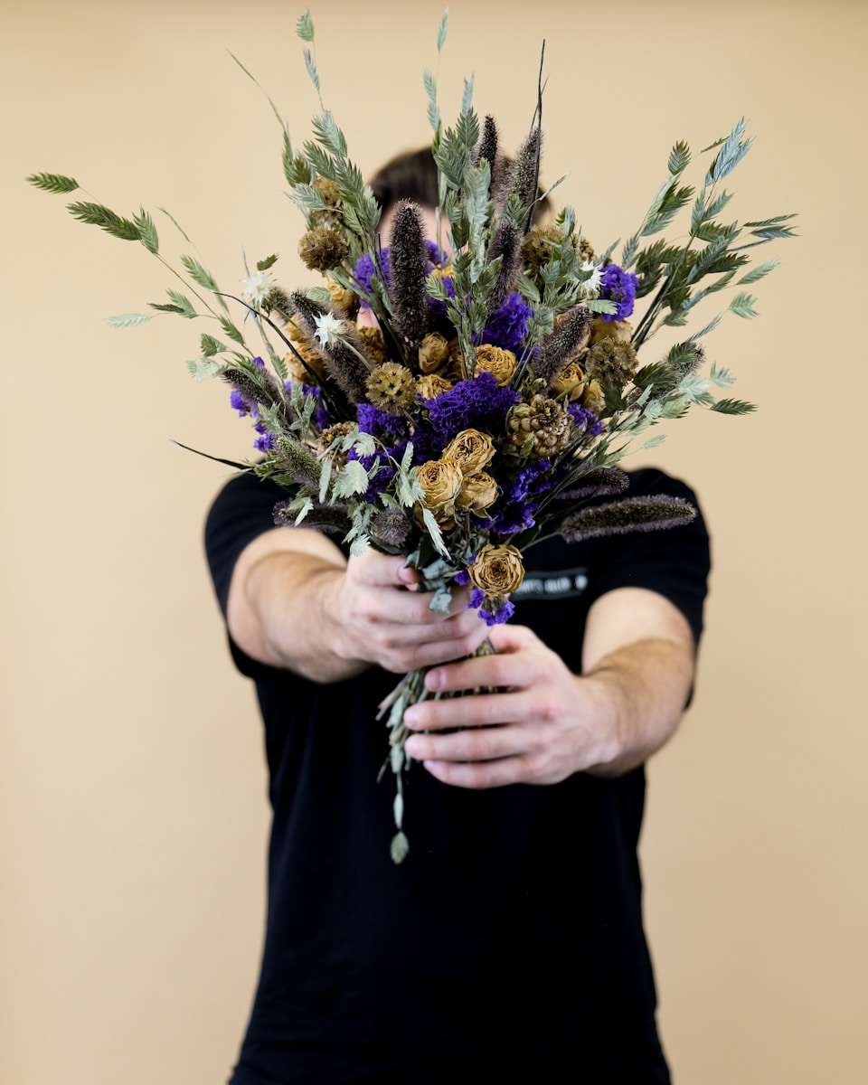 a man holding a bouquet of flowers in his hands